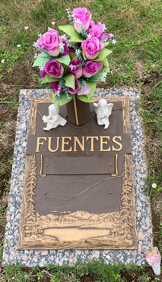A bronze plaque on a granite base with a bronze vase