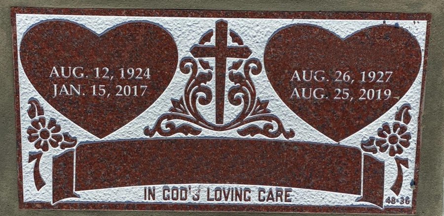 A flat marker in red granite set flush with the ground